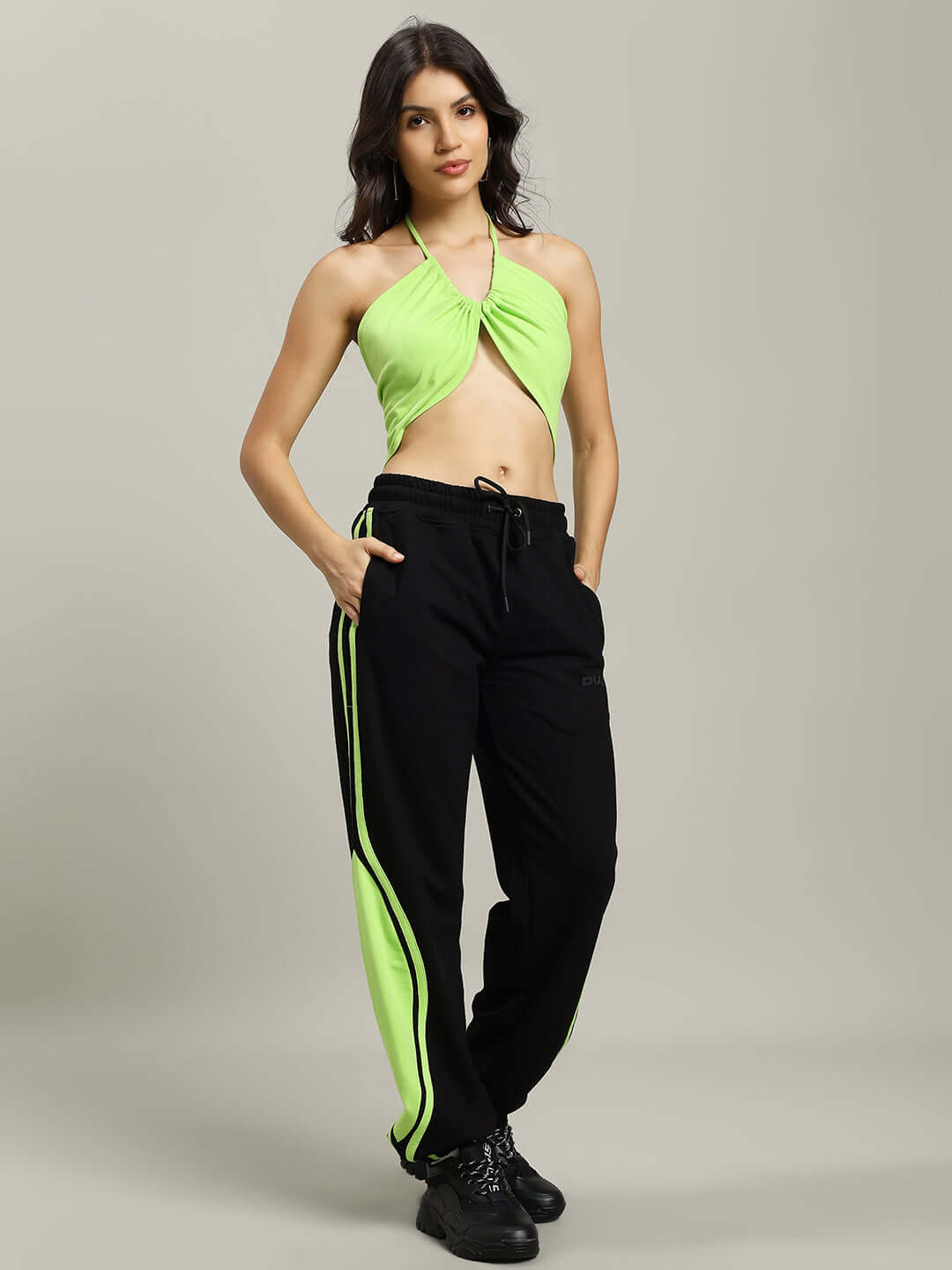 Model wearing Women's Vector Baggy Joggers in black with neon accents, paired with a neon green top, showcasing a stylish and comfortable outfit.