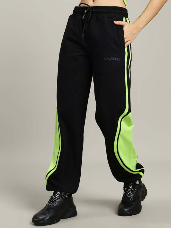 Women's black joggers with neon green accents by DUDS, featuring a baggy fit and drawstring waist, ideal for customizable comfort.