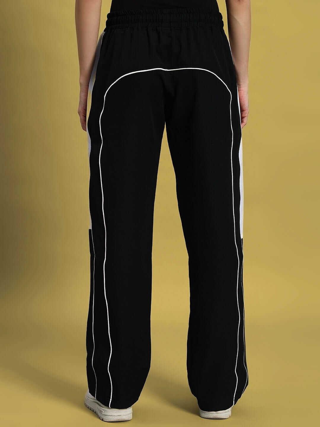 Back view of women's black versatile parachute cargo pants with white piping, perfect for custom fit and style.