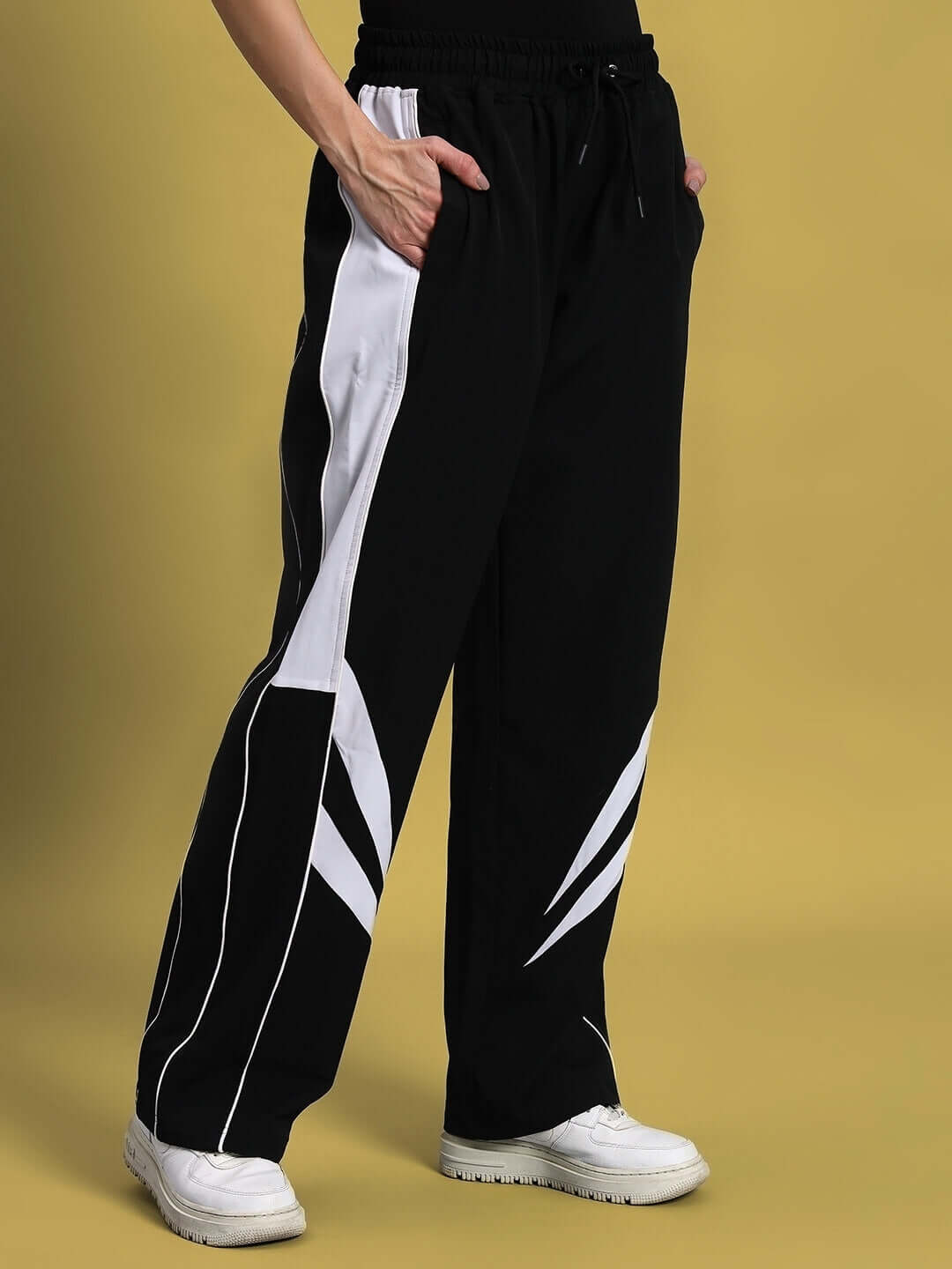 Black women's parachute cargo pants with white accents and pockets, featuring a customizable fit option for prepaid orders.