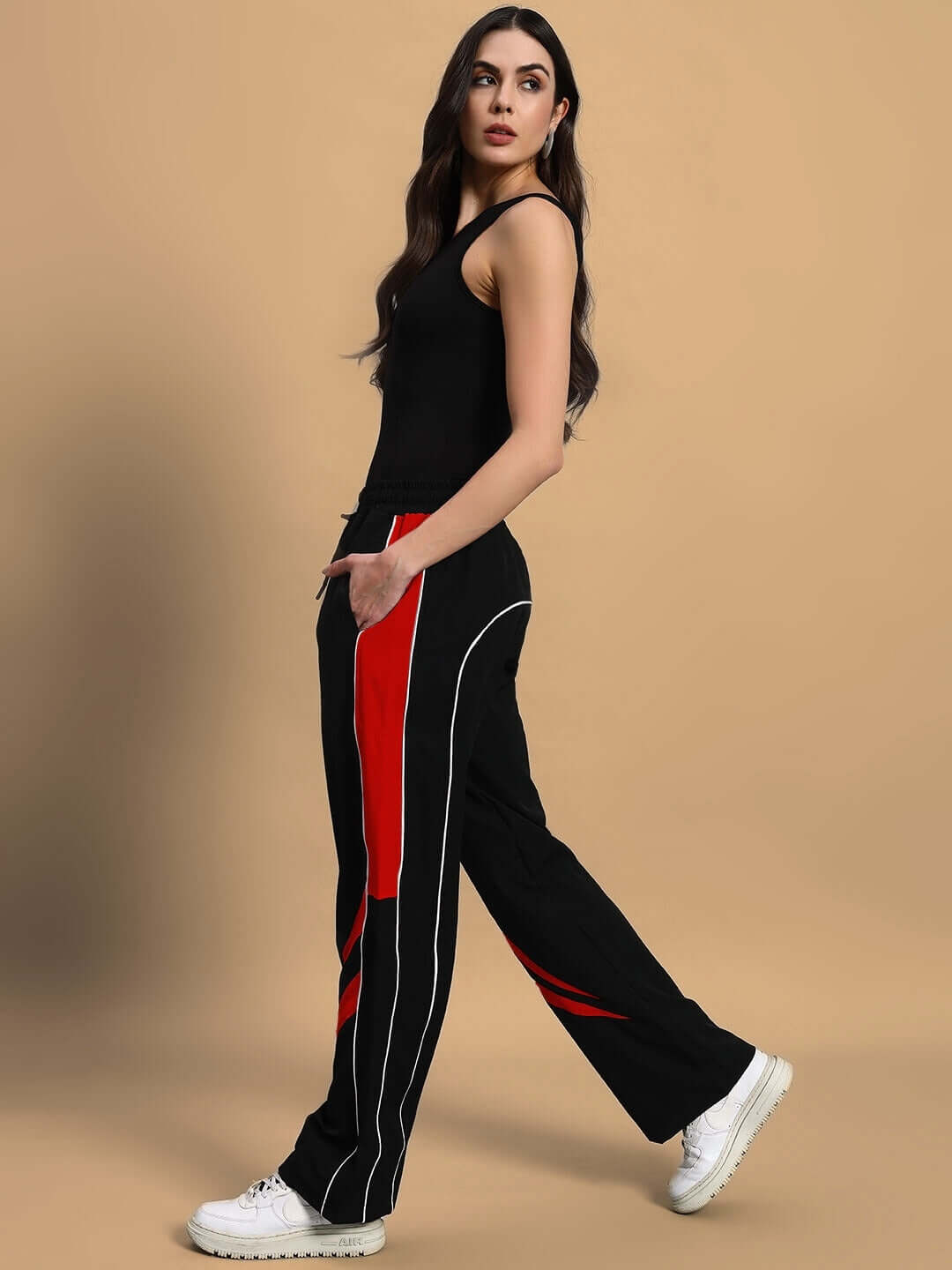 Model wearing women's versatile black-red parachute cargo pants with white sneakers.