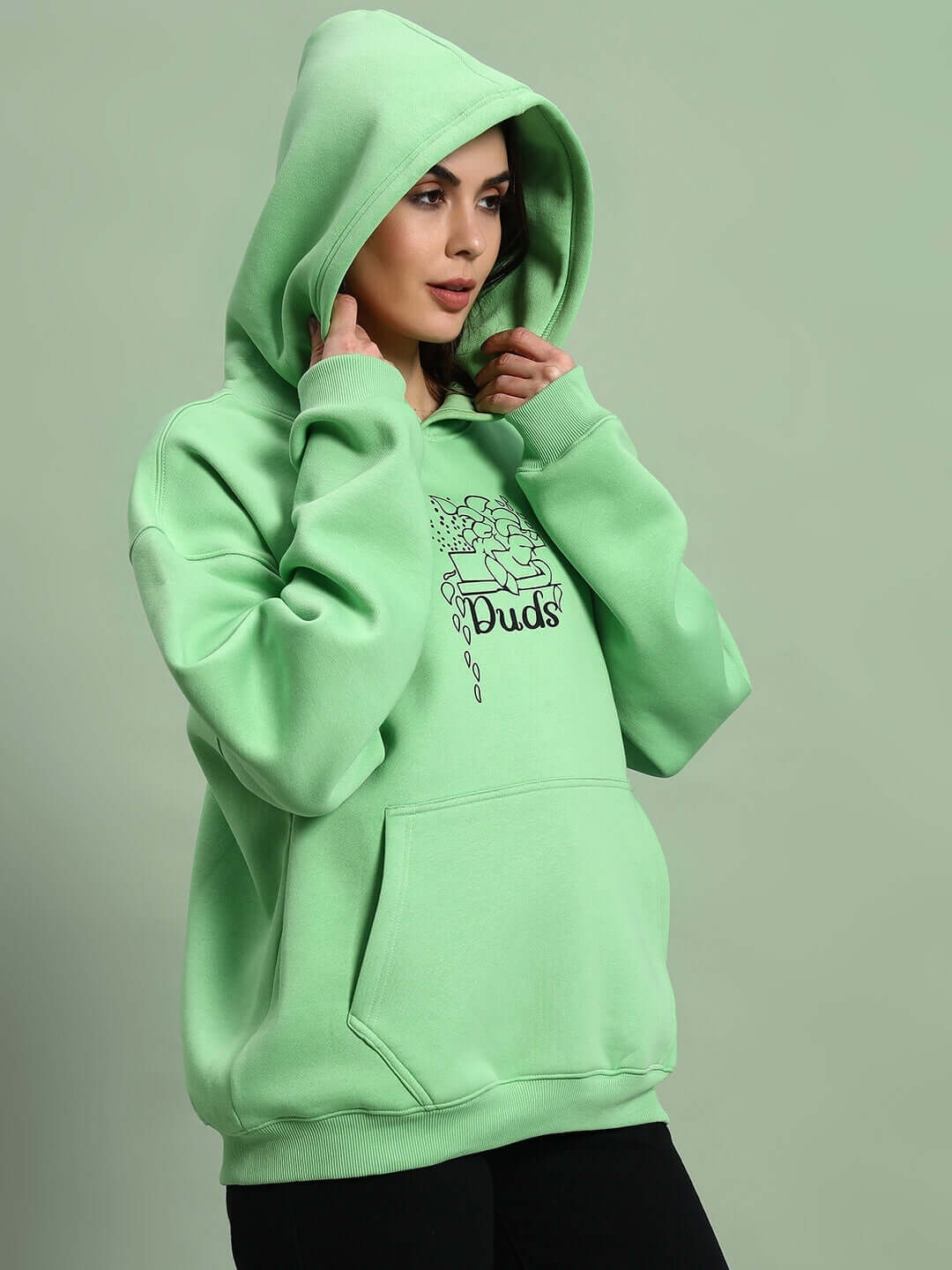 Model wearing WOMEN VOODO FLEECE OVERSIZED HOODIE GREEN with a hood up, showcasing vibrant color and cozy fleece material.