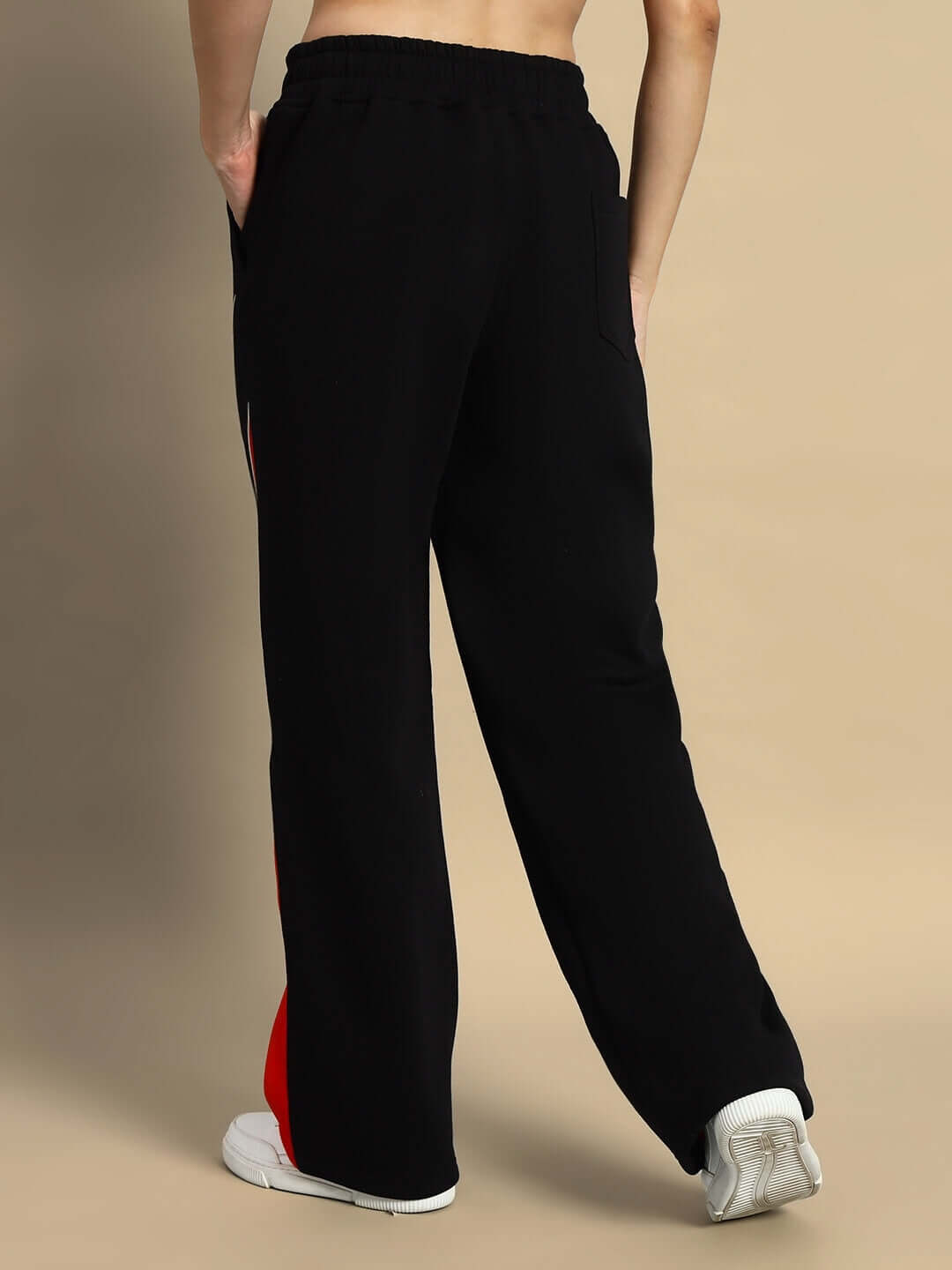 Back view of women's black and red colorblock cargo pant, featuring relaxed fit and elastic waist, styled with sneakers.