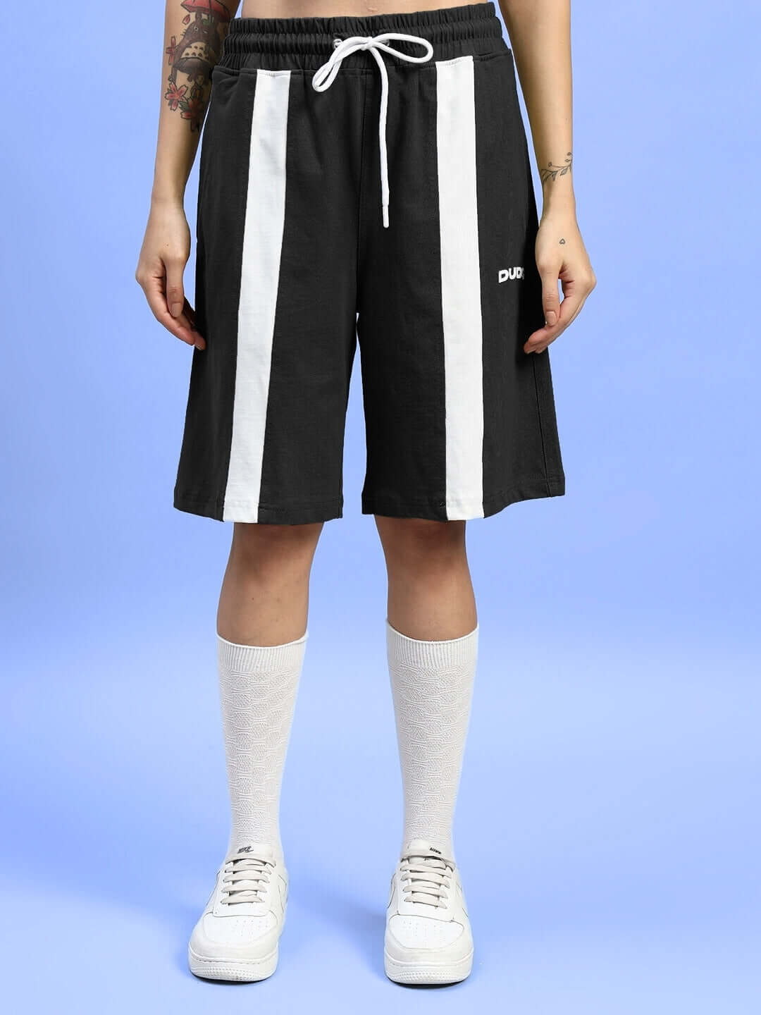 Women's black wideline regular fit shorts with white stripes, customizable size options, shown with white sneakers and socks.