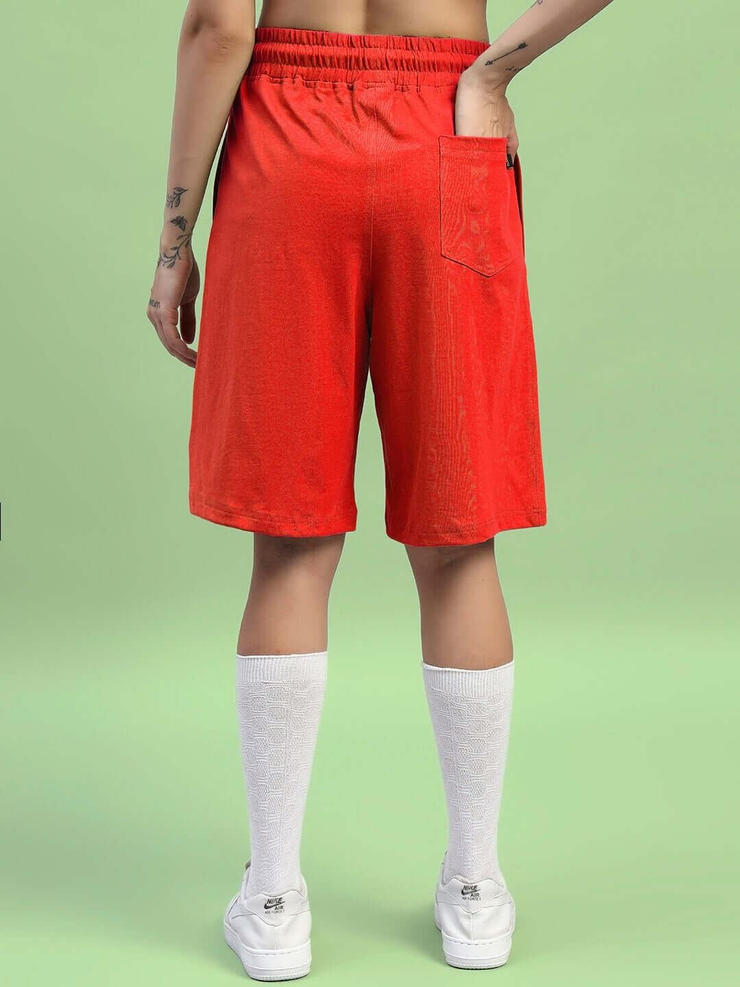 Back view of a woman wearing red wideline regular fit shorts with white knee-high socks.