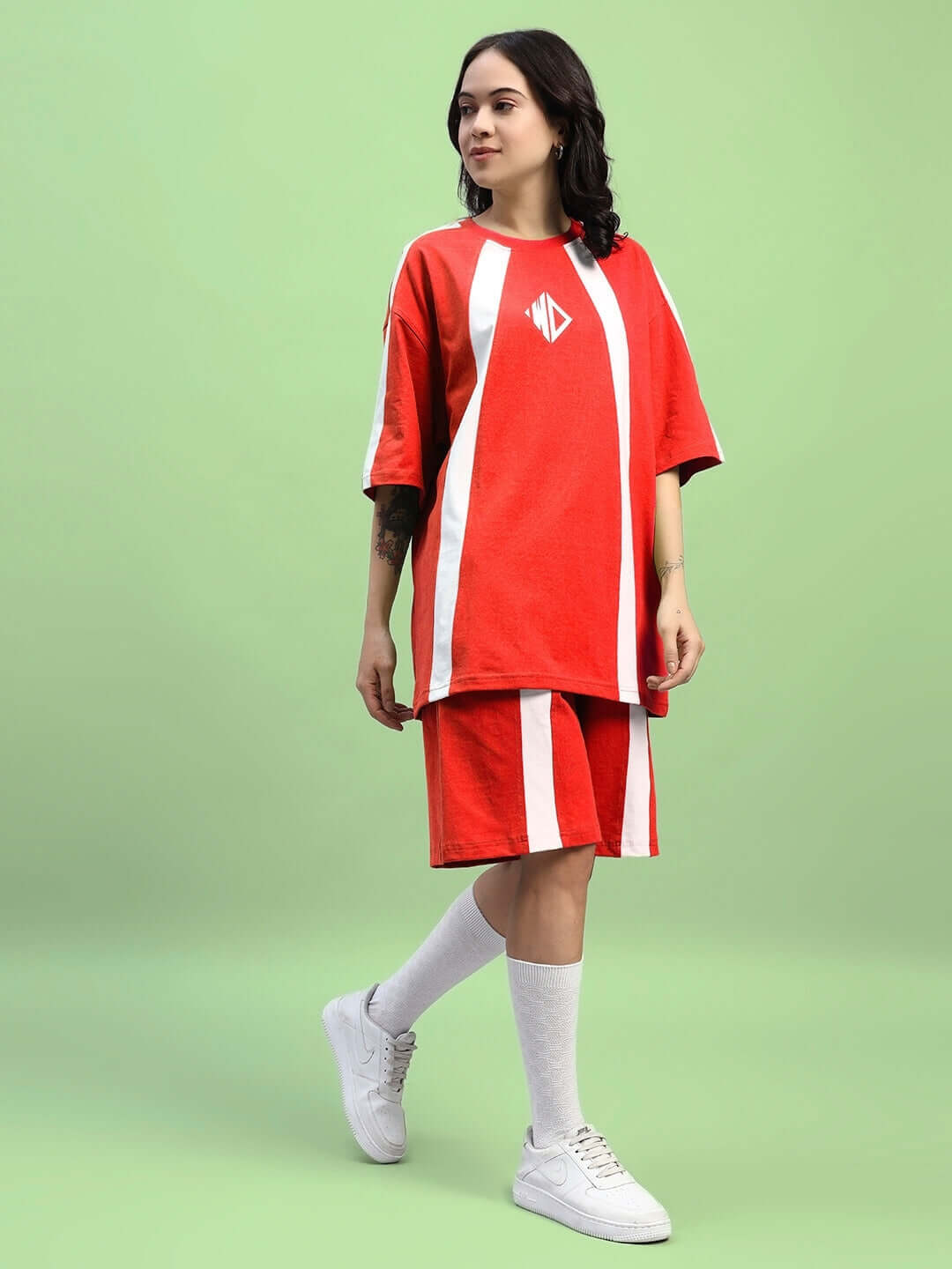 Woman wearing WOMENS WIDELINE SUMMER CO-ORD SET RED on green background, showcasing vibrant red two-piece outfit with white accents.