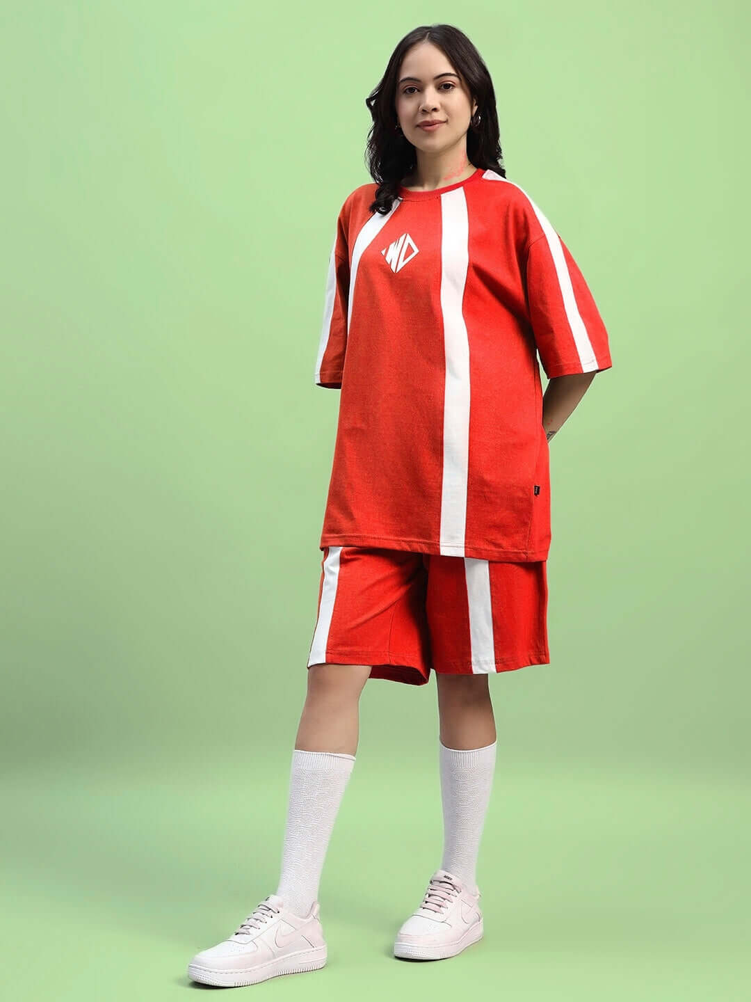 Women's red summer co-ord set with white stripes, featuring a top and shorts, made from premium cotton terry lycra, modelled on green background.