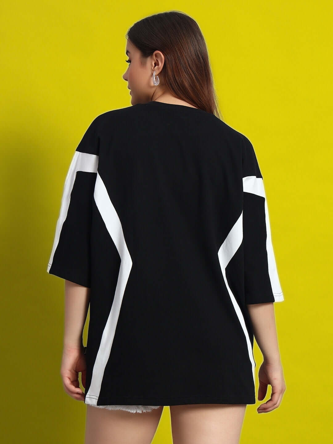 Back view of Women's Wild Force oversized black-white T-shirt made of premium cotton fabric, featuring distinctive white stripes.
