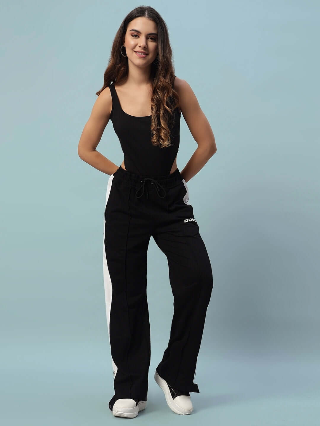 Model wearing Women's Wonder Slit Zipper Joggers in Black-White, showcasing stylish athletic fit. Tailored by DUDS, customizable option available.