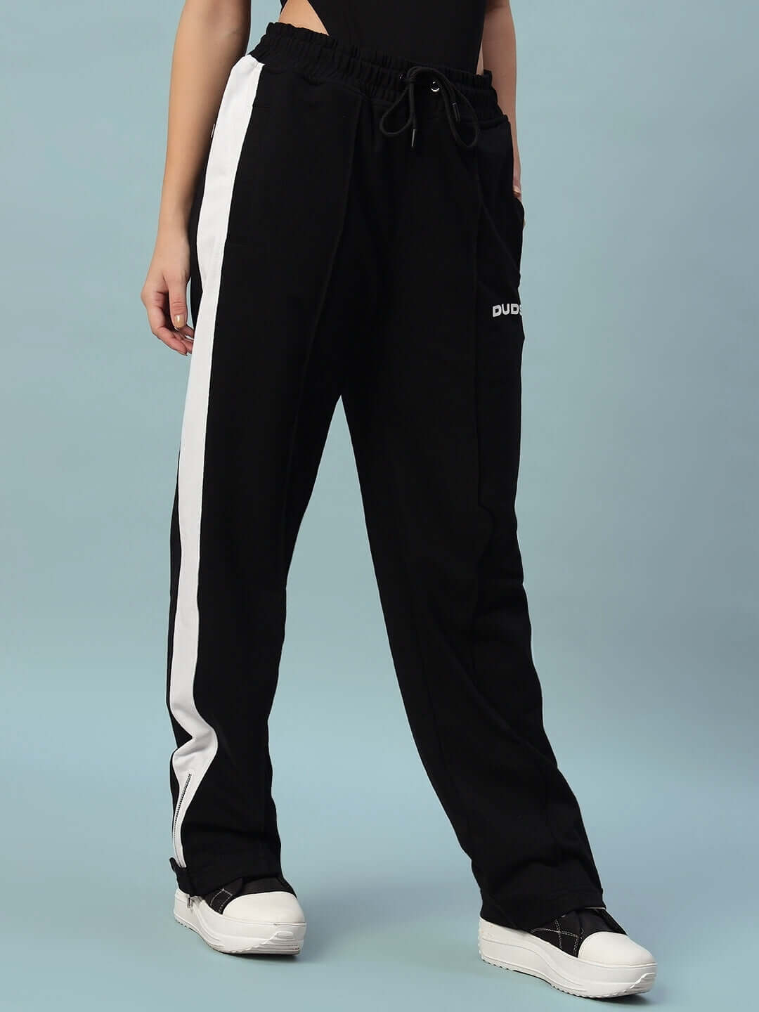 Woman wearing black and white Women's Wonder Slit Zipper Joggers by DUDS, showcasing stylish and comfortable fit.