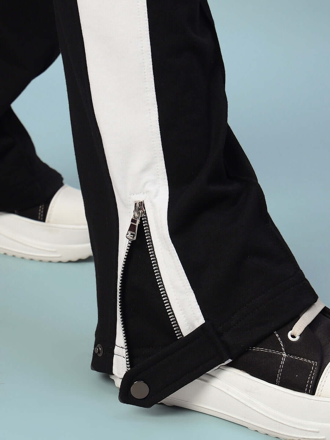 Close-up of black-white women's joggers with a zipper detail, showcasing modern design and comfort.