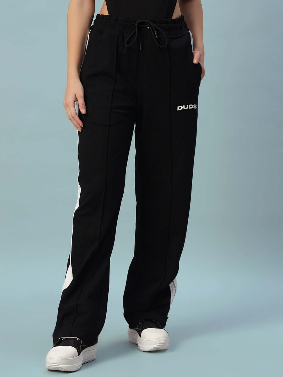 Woman wearing black and white women's wonder slit zipper joggers by DUDS, featuring a comfortable fit and stylish design.