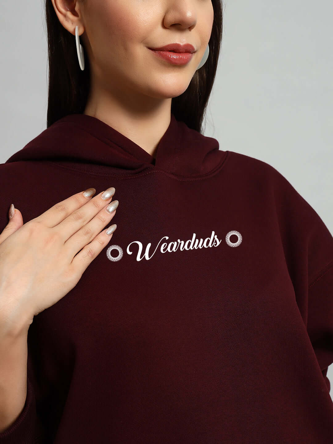 Woman wearing WOMEN'S YANTRA FLEECE CO-ORD SET WINE with hand on chest, displaying soft fleece material and stylish design.