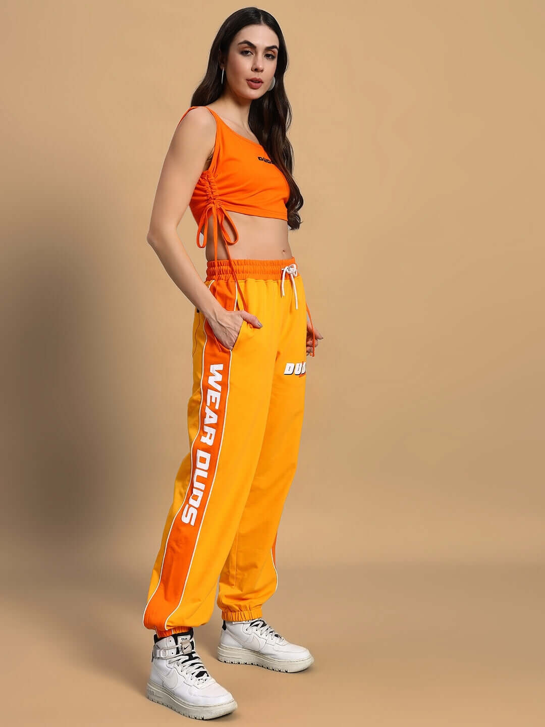 Model wearing women's squeeze co-ord set in yellow-orange with vibrant print, featuring premium heavy gauge fabric, styled for comfort and elegance.