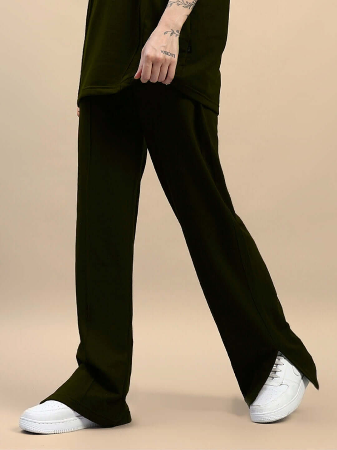 Olive green women's joggers with side slits, showcased with white sneakers, crafted by DUDS.