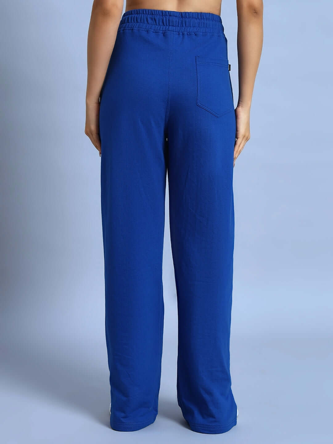 Back view of women's Zion side slit joggers in royal blue, showcasing elastic waistband and tailored design by DUDS.