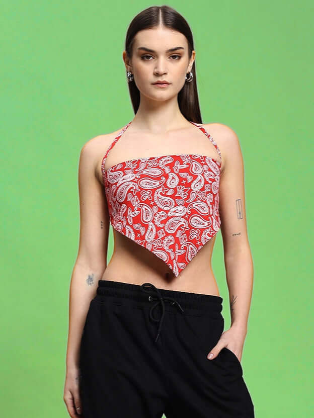 Model wearing Women's Ziva Crop-top in red with paisley design, made from 100% cotton fabric, styled against a green background.