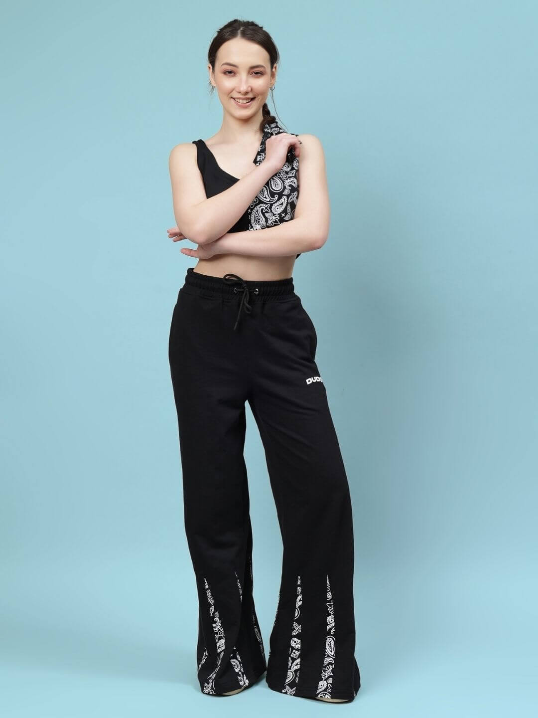 Woman wearing Women's Ziya Co-ord Set in black with paisley details, made of premium cotton elastane fabric, standing against blue background.