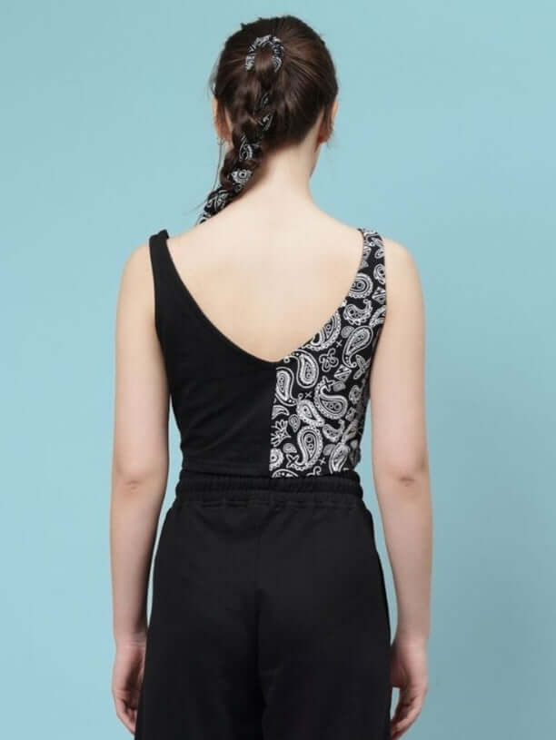 Woman wearing the WOMEN'S ZIYA CROP-TOP in black with paisley design, made of premium 100% cotton fabric, rear view on a blue background.