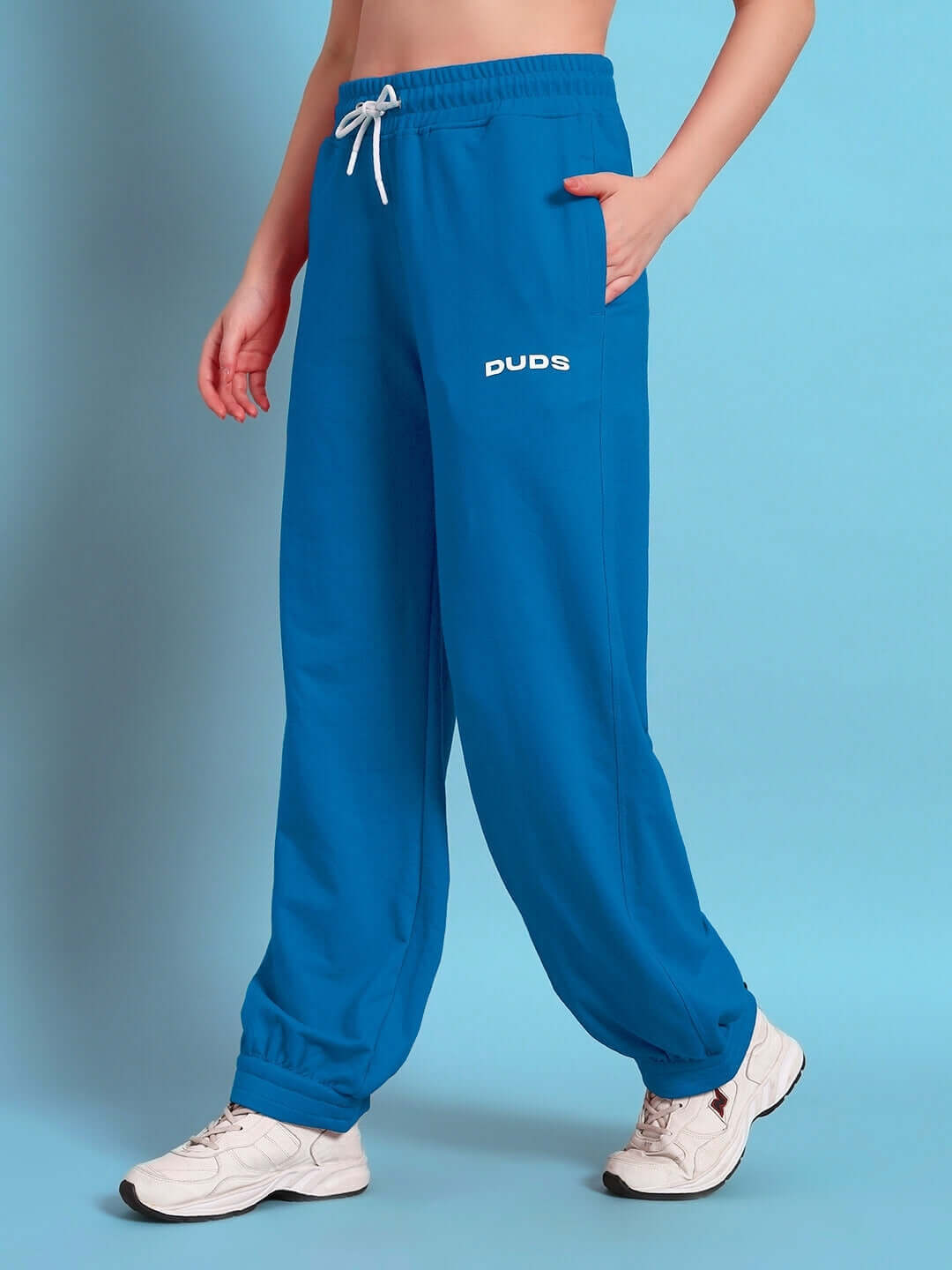 Woman wearing blue women's Austrian relaxed-fit joggers by DUDS. Made to order with custom fit options available.