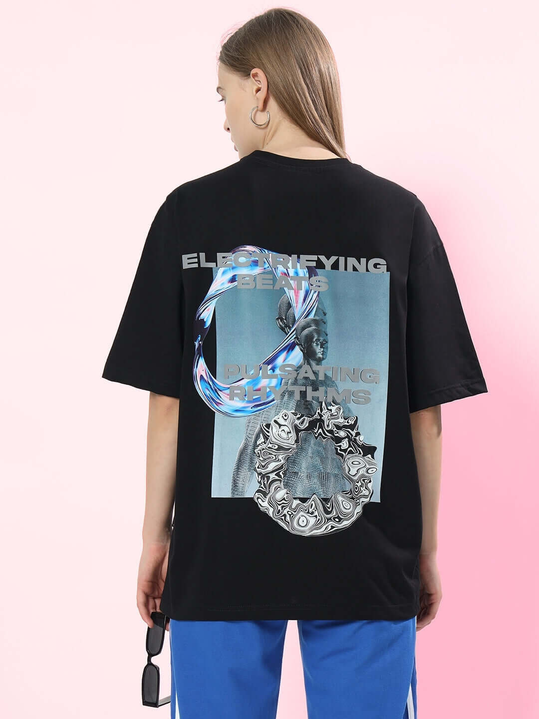 Model wearing a black oversized T-shirt with 'Pulsating Rhythms' design, crafted from premium cotton blend, perfect for casual wear.