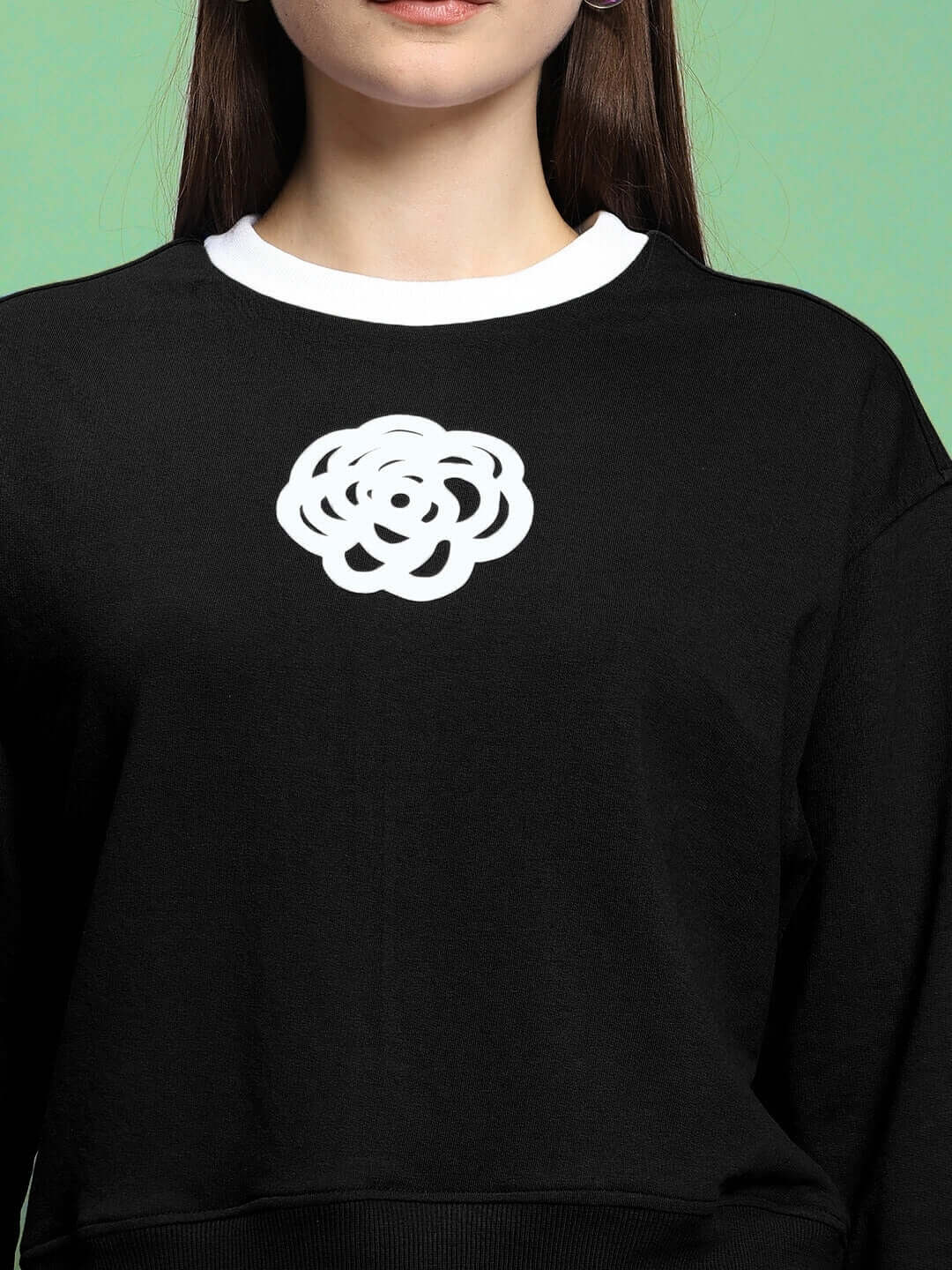 Close-up of a woman wearing a black Women's JessFlick Relaxed Fit Sweatshirt with a white emblem, made of premium cotton French Terry.