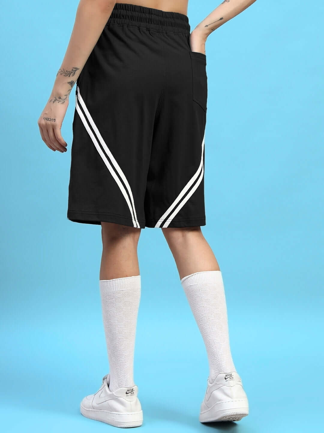 Person wearing WOMENS STAR JUMPER SUMMER CO-ORD SET BLACK with striped shorts, showcasing a stylish streetwear look.