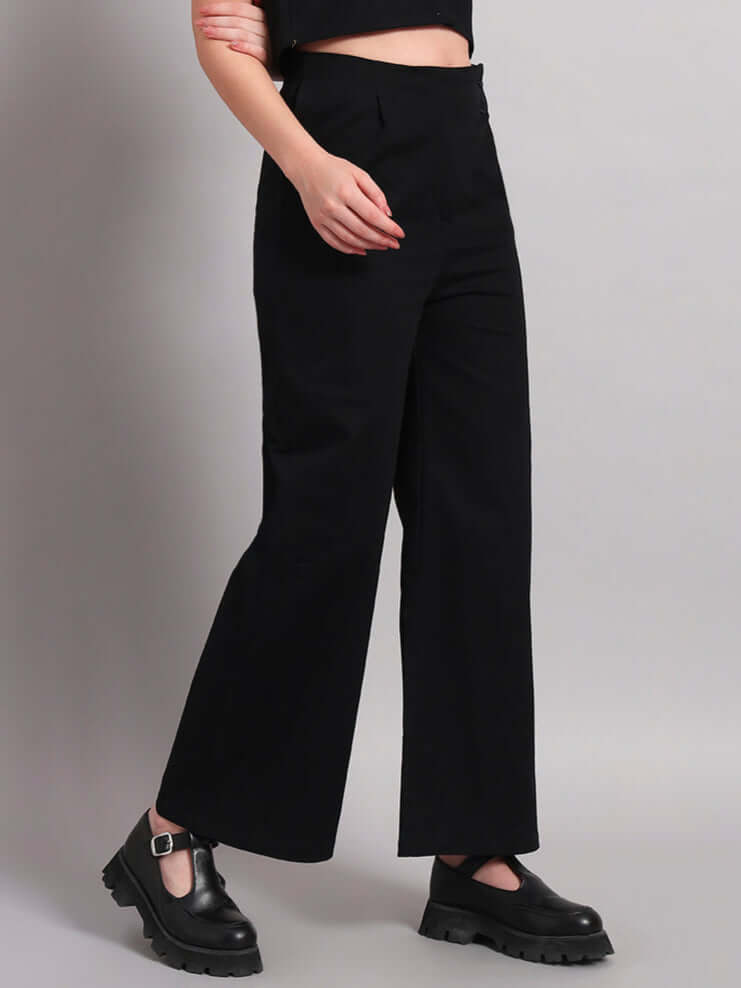 Model wearing women's chic relaxed fit black joggers paired with stylish shoes, showcasing fashion-forward casual wear by DUDS.