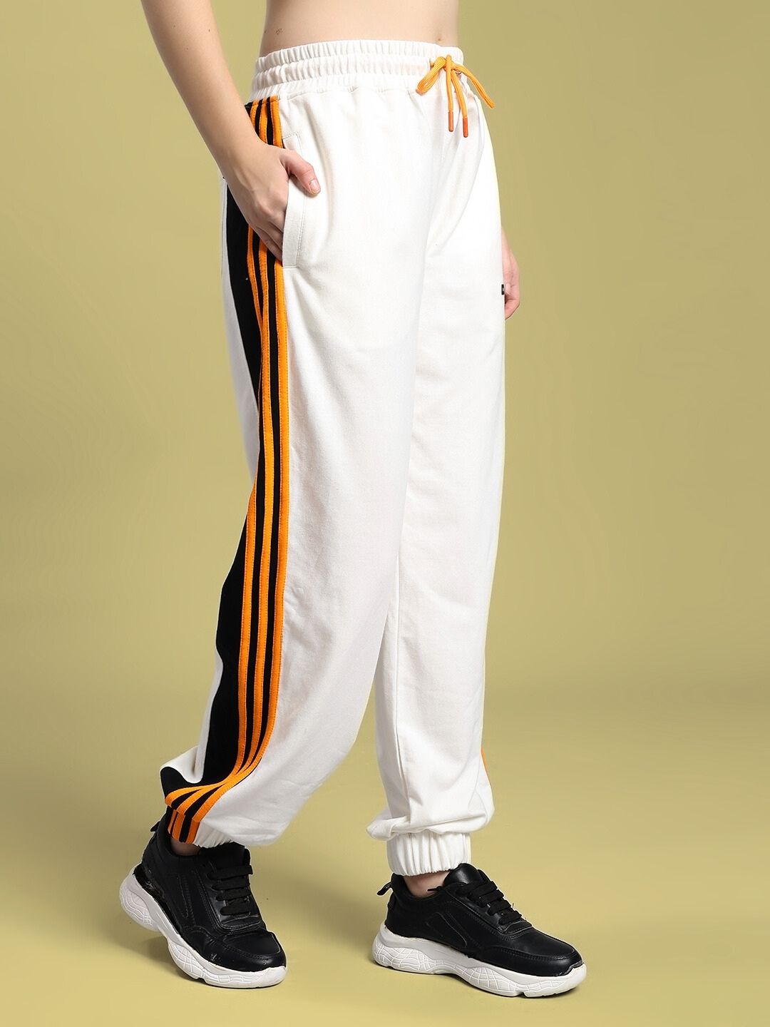 Woman wearing WOMEN'S COMFORT FLEX STRIPE JOGGER OFF-WHITE with vertical stripes and sneakers.