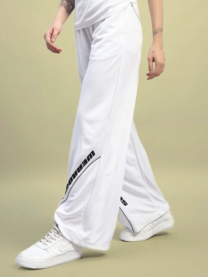 Model wearing WOMEN'S CUBBY RELAXED FIT BAGGY JOGGERS WHITE with sneakers and casual style.