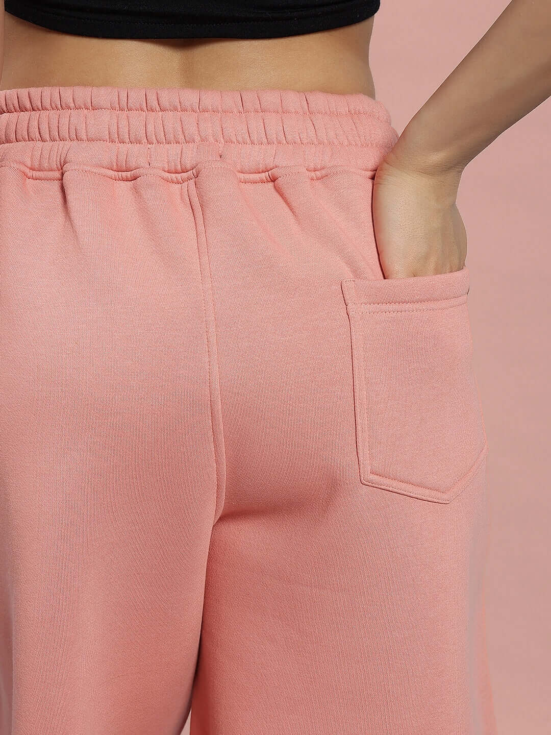 Close-up of WOMEN DELIBERATE FLEECE SHORTS PEACH with pocket detail and elastic waistband, highlighting comfort and style for modern fashion.
