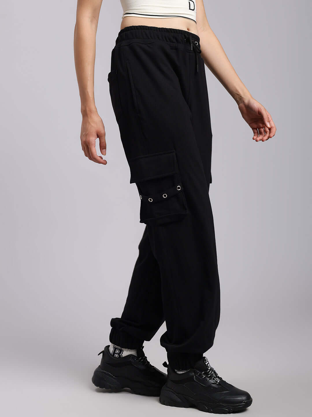 Model wearing Women's DUDS Commando Joggers in black, featuring cargo pockets, showcased for made-to-order customization.