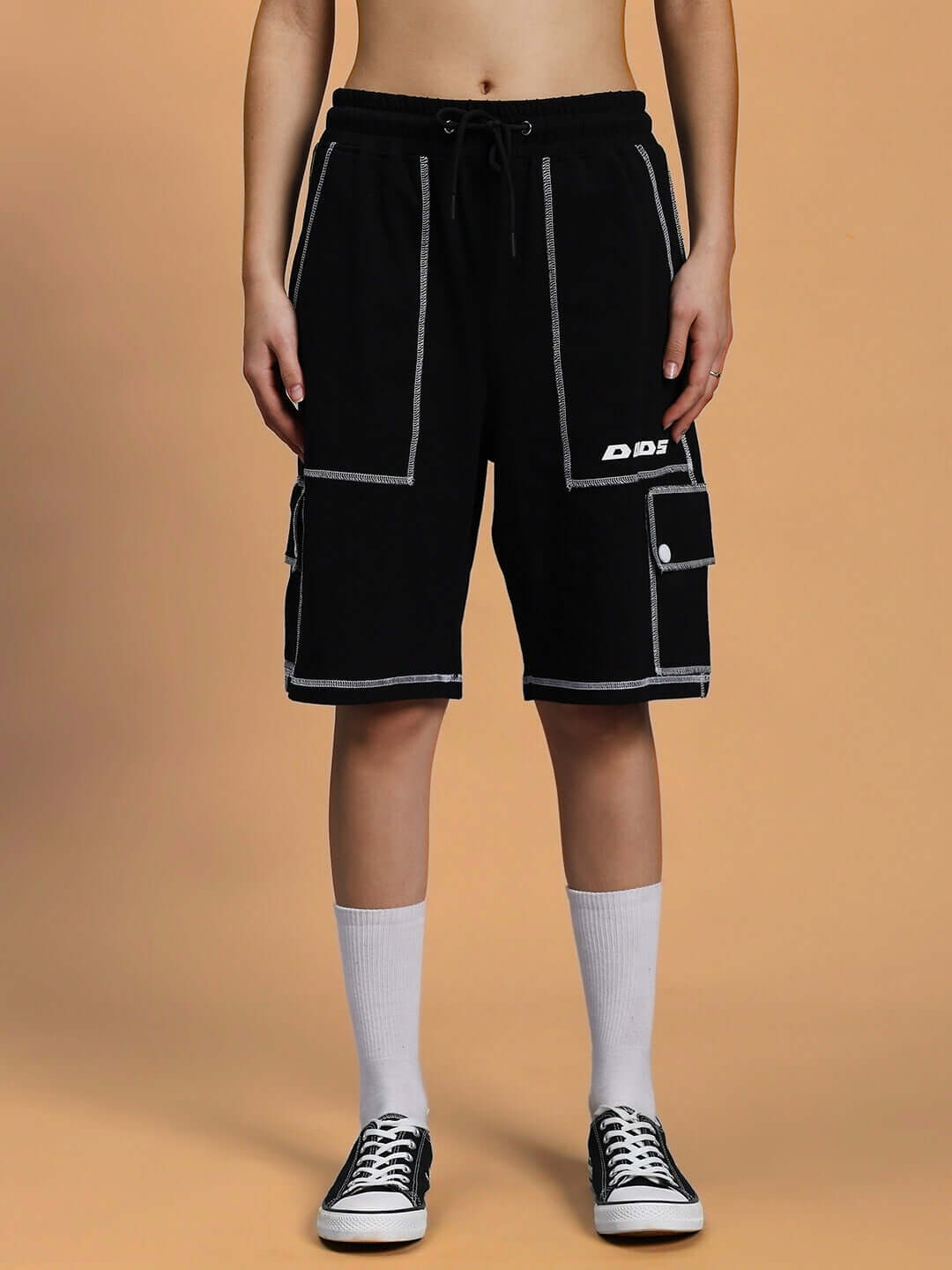 Woman wearing black summer co-ord set with white contrast stitching, featuring premium cotton and Lycra fabric, styled with sneakers.