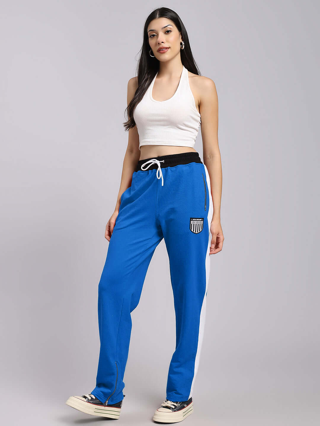 A woman wearing DUDS Women's Elegant Relaxed-Fit Joggers in blue, styled with a white top, emphasizing casual elegance and comfort.