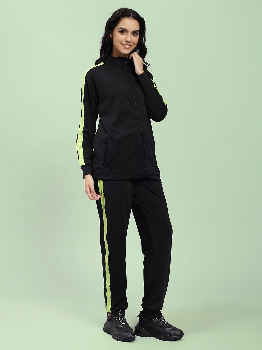 Woman wearing WOMEN HIGH PERFORMANCE CO-ORD SET BLACK, featuring a zip-up hoodie and tapered joggers, perfect for athleisure and workouts.