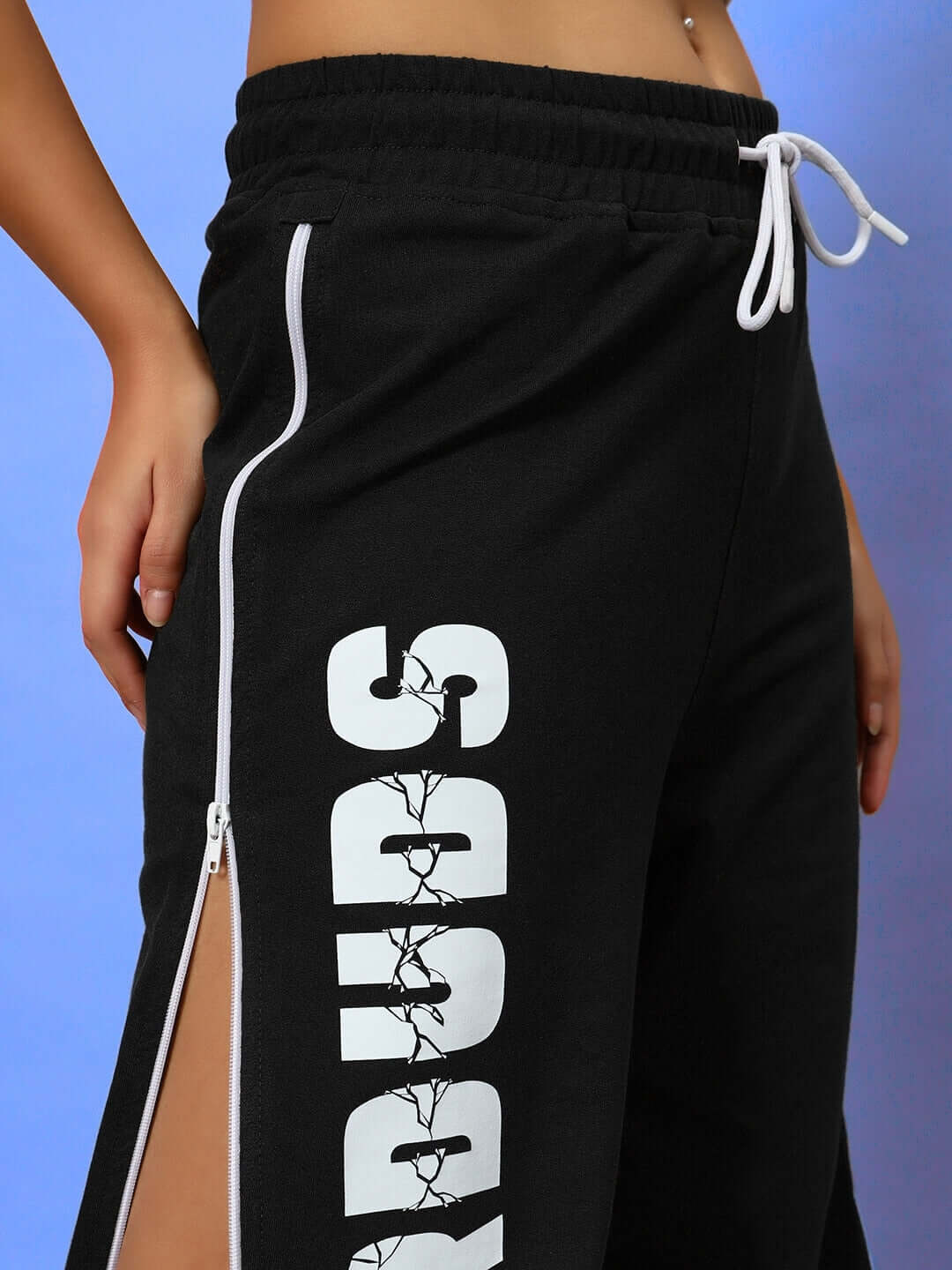 Close-up of women's black joggers from DUDS featuring side zippers and bold branding, showcasing stylish and comfortable design.
