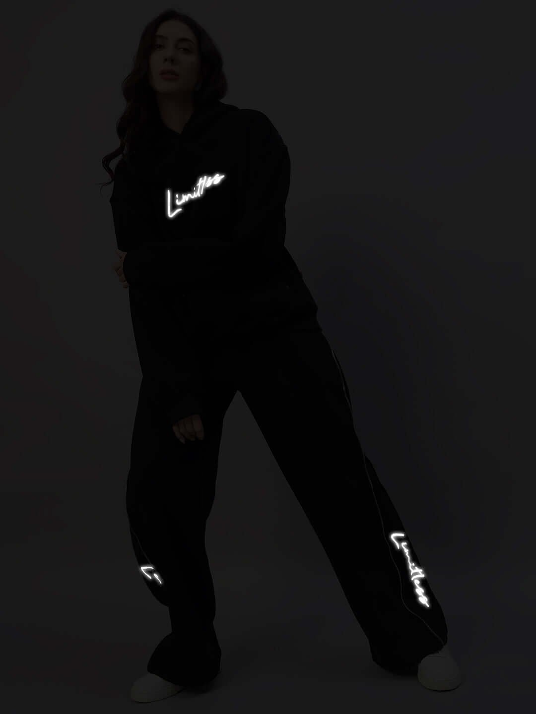 Model wearing Women's Limitless Fleece Reflector Co-ord in black with reflective logo accents.