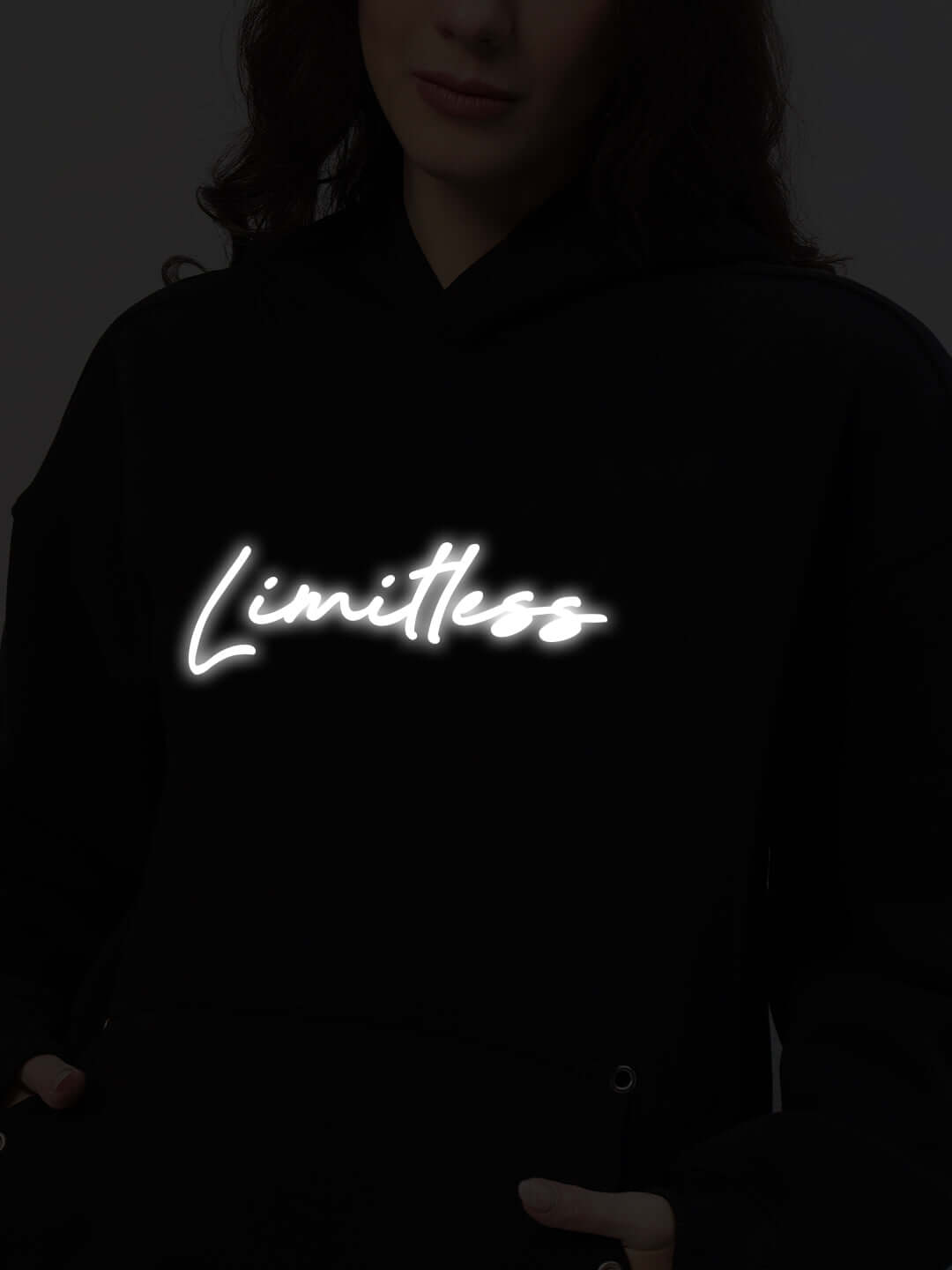 Women's Limitless Fleece Reflector Hoodie in Black with glowing 'Limitless' text, showcasing modern style and reflective detailing.
