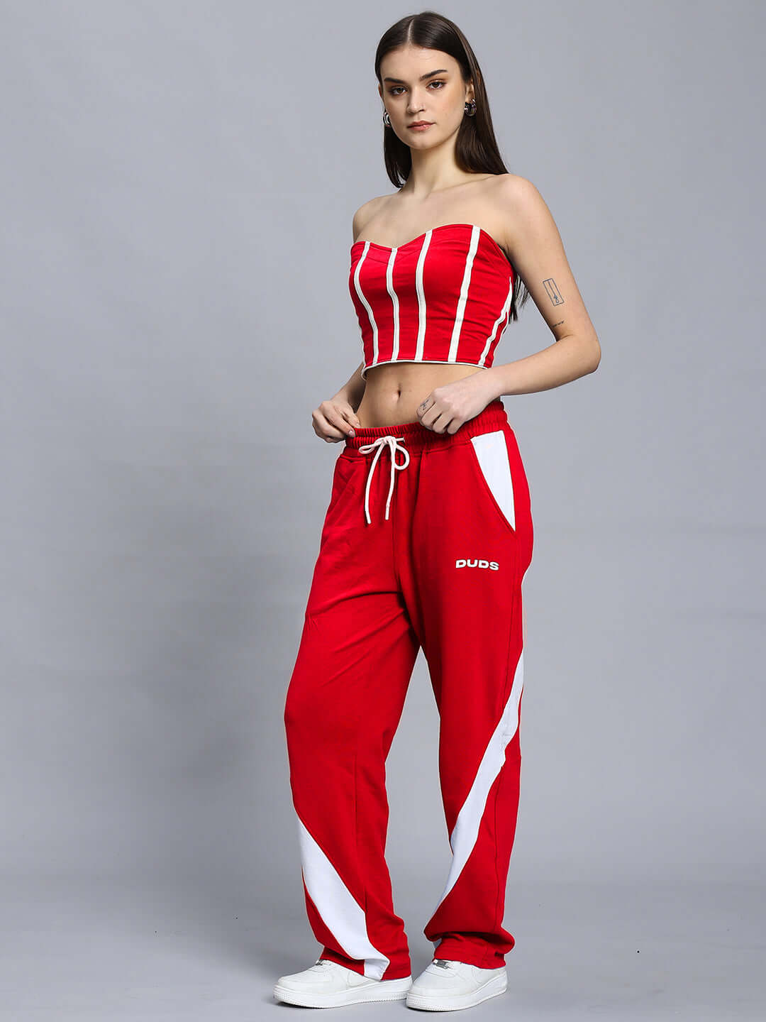 Woman wearing red Livianna Cool Co-Ord set with striped strapless top and relaxed fit joggers with elastic waistband and drawstring.