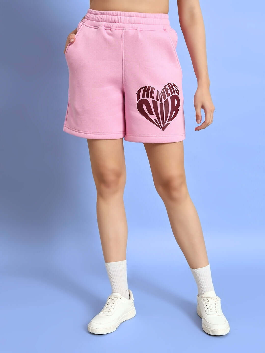 Model wearing WOMEN LOVERS CLUB FLEECE SHORTS PINK with elastic waistband and side pockets for comfort and style.
