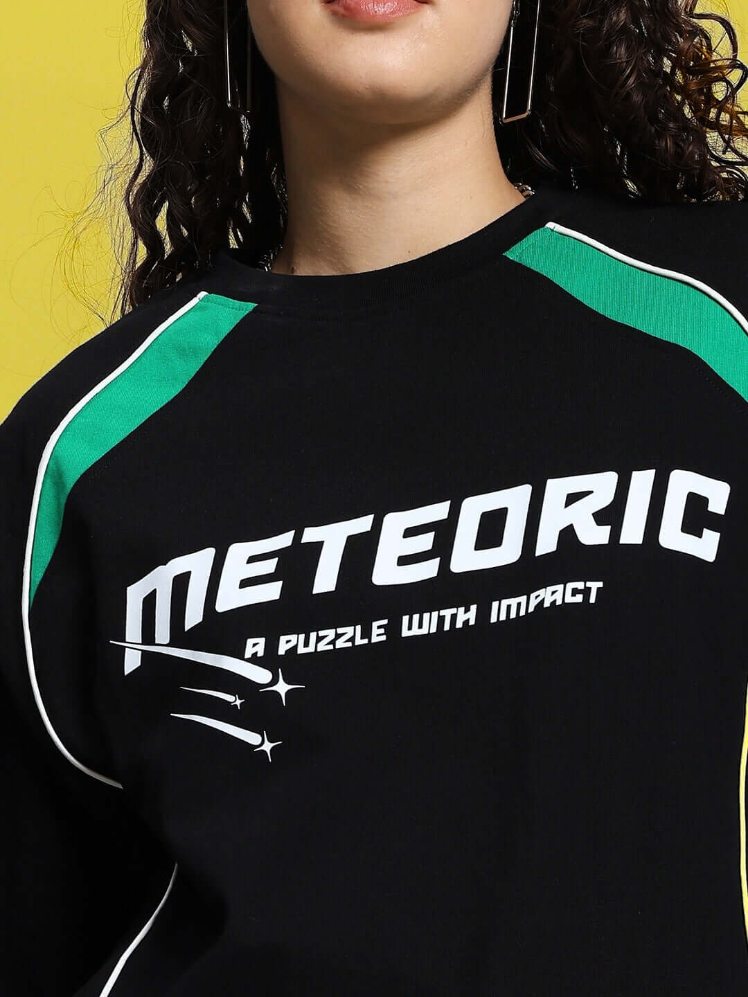 Black oversized women's T-shirt with 'METEORIC' print, green and white accents, made from premium cotton and elastane blend.