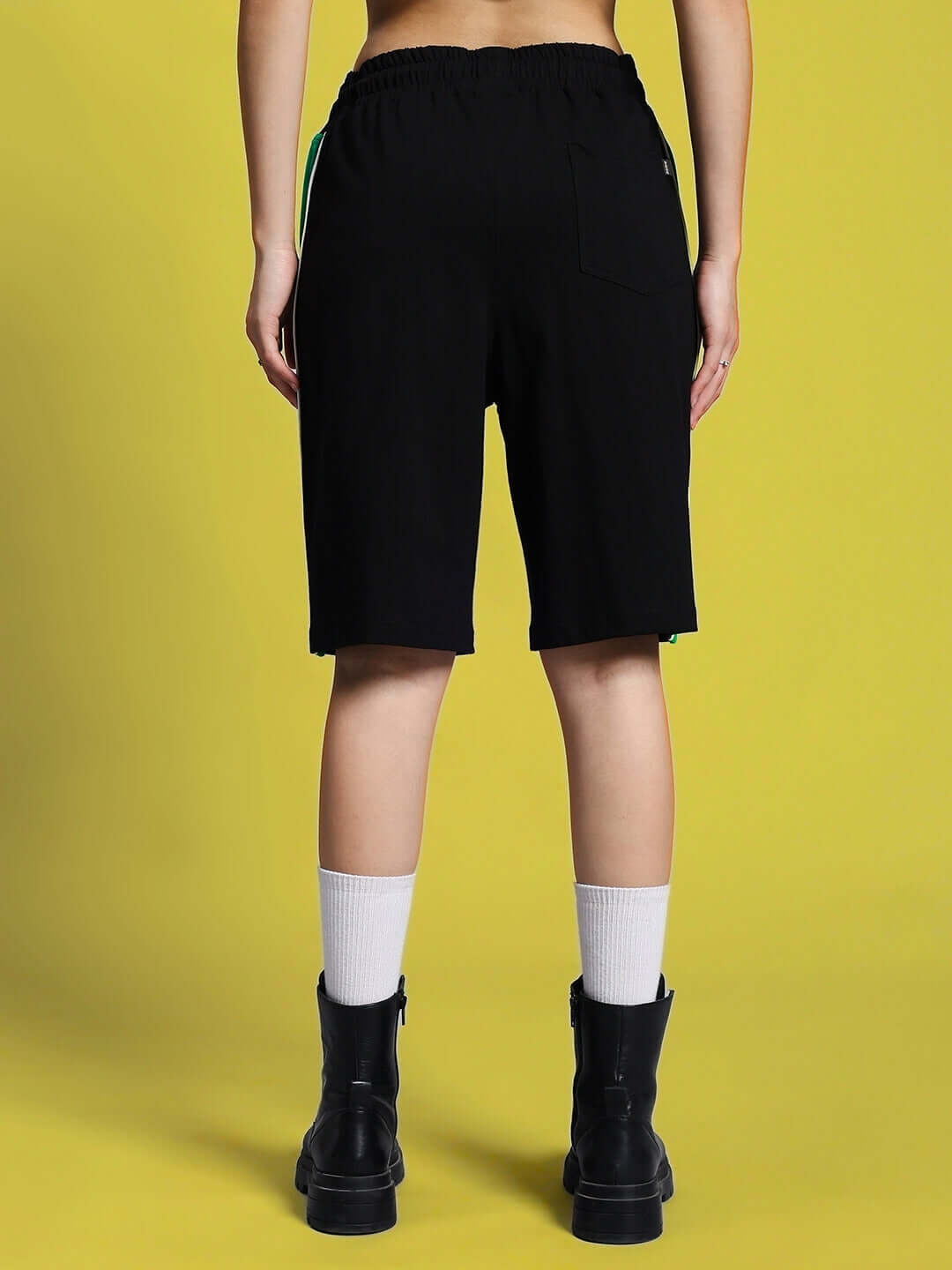 Back view of Women's Meteoric Regular Fit Shorts in black, featuring elastic waistband and knee-length design, ideal for casual wear.