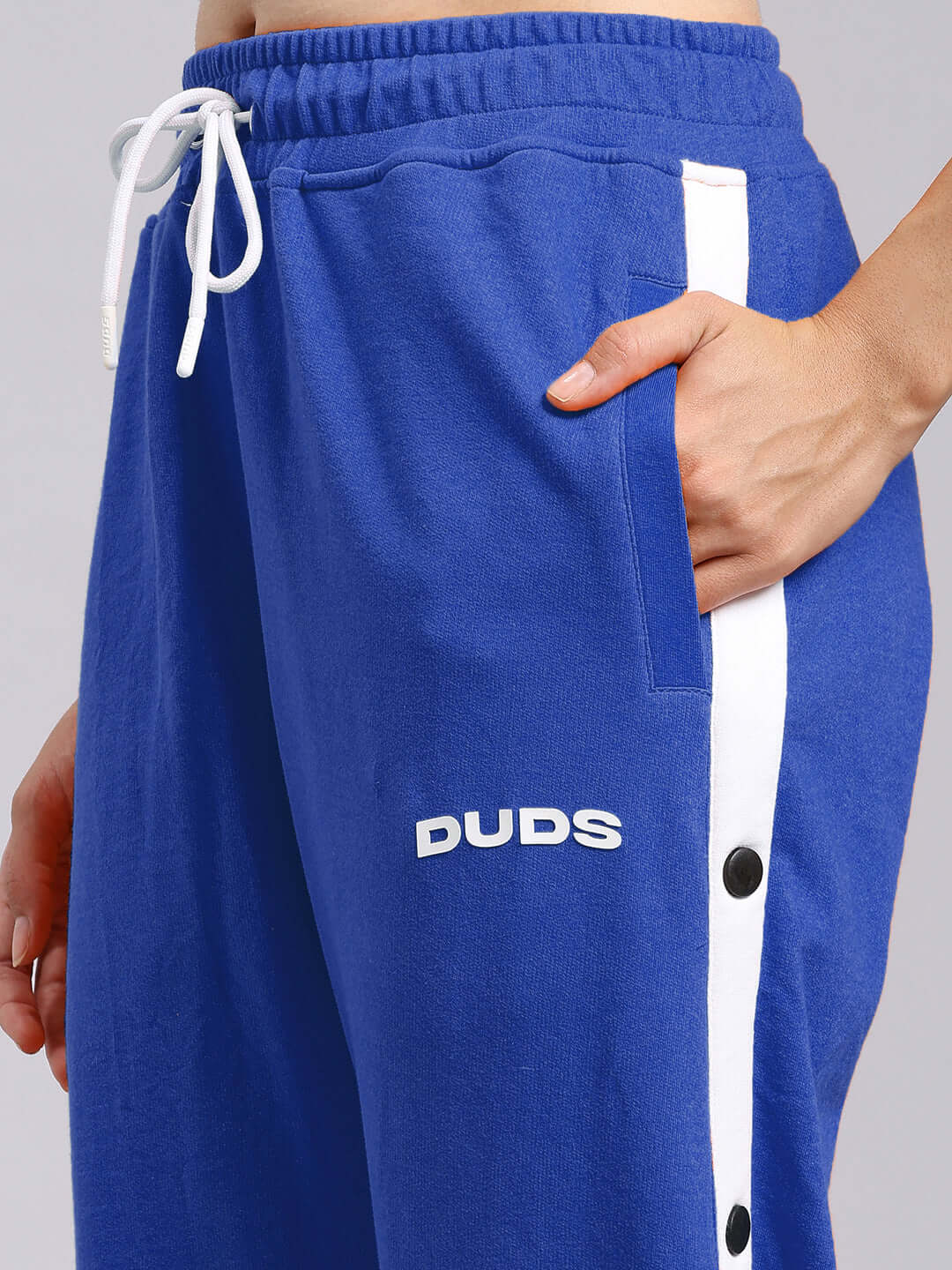Close-up of Women's Miller Relaxed Fit Joggers in blue by DUDS, featuring white side stripes and side pocket detail.