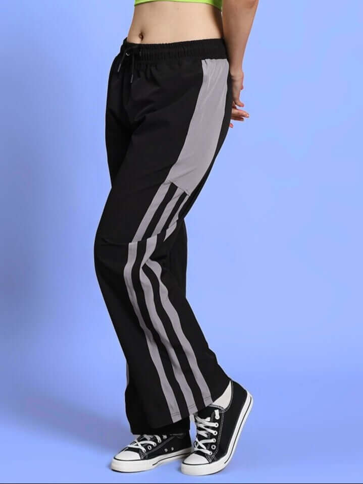 Model wearing black women's Morgan relaxed fit cargo pants with elastic waistband and drawstring, featuring a sporty stripe design.