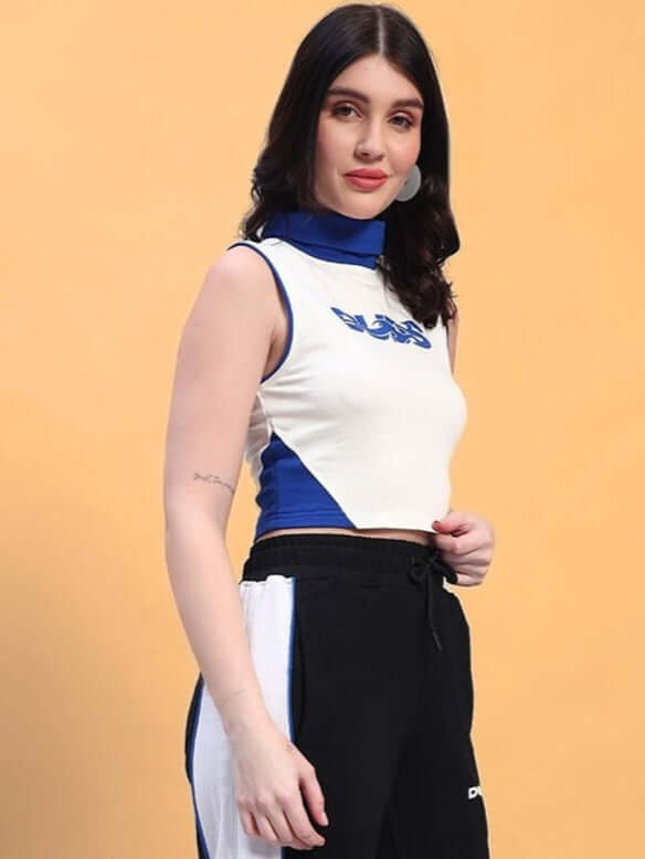 Woman wearing white MYSKY crop-top with blue accents, made from premium cotton French Terry Lycra, photographed on a peach background.