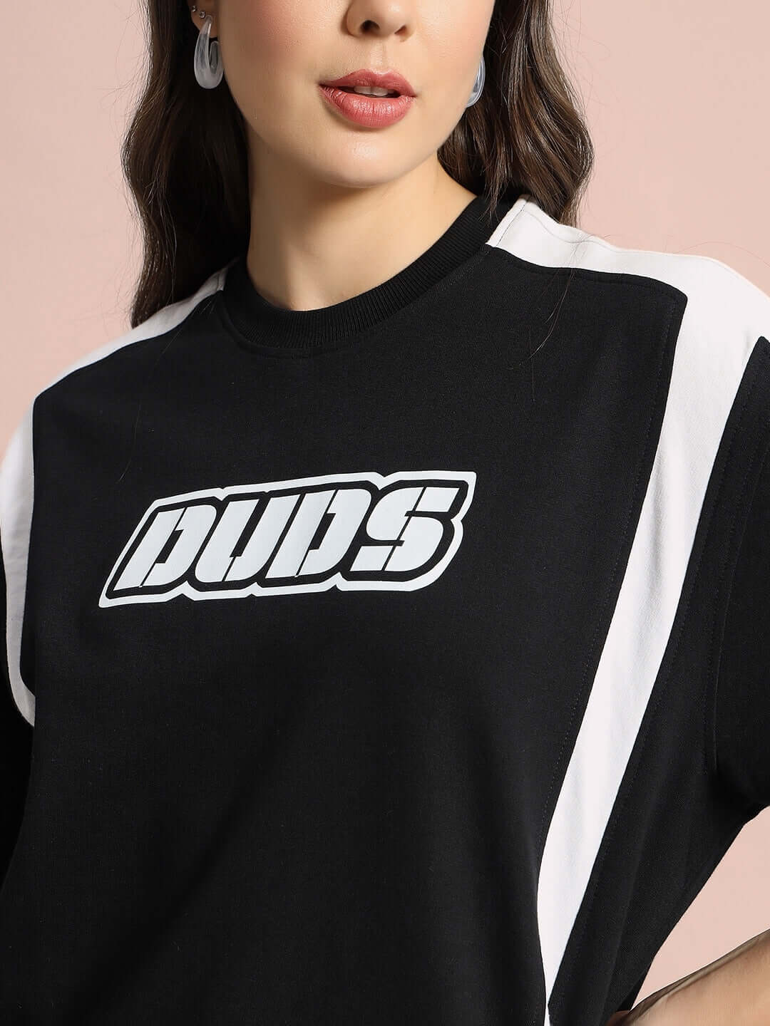 Woman wearing a Women's Ninja Storm oversized black t-shirt with bold logo, made from premium cotton fabric.