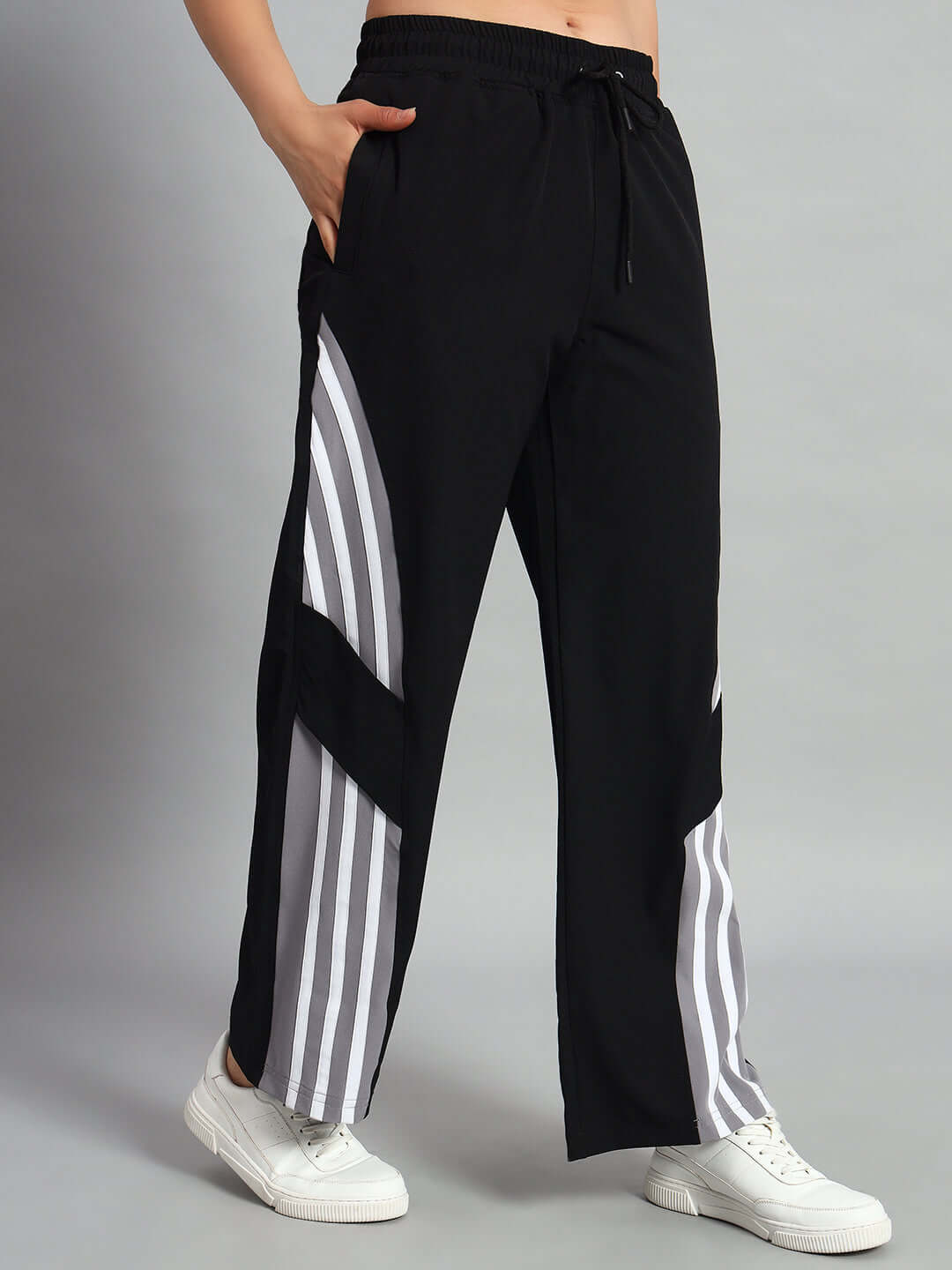 Women's black NITRO relaxed fit cargo pants with white stripes, available in customizable sizes, shown worn with sneakers.