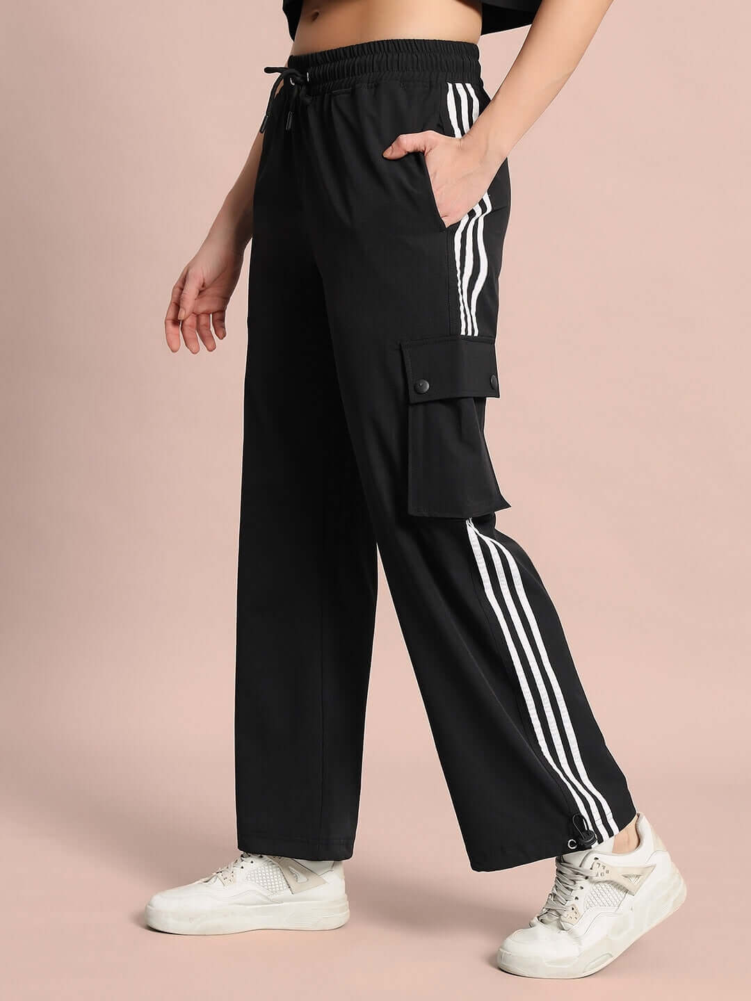 Model wearing Women's Nova Relaxed Fit Black Cargo Pants with striped design and pocket detail.