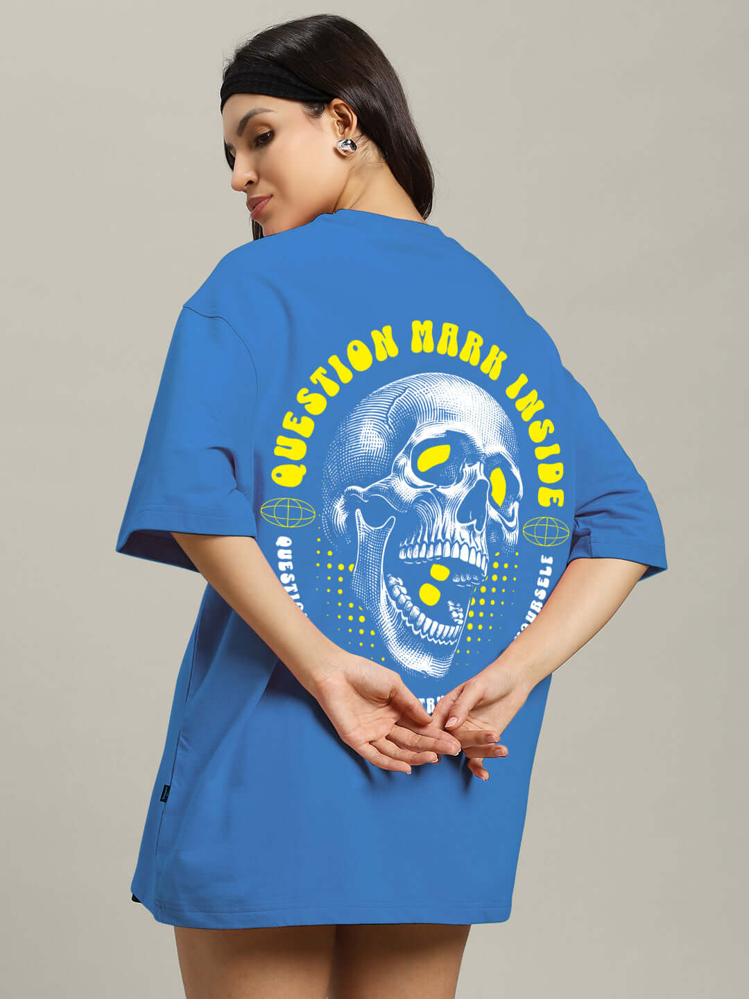 Woman wearing blue oversized T-shirt with skull graphic and slogan 'Question Mark Inside' on the back.