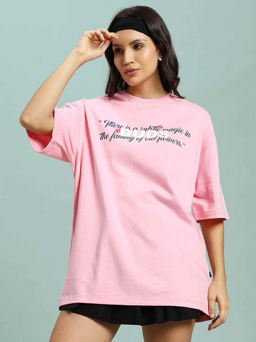 Woman wearing a pink 'Falling Flower' t-shirt made from premium cotton, featuring a printed quote, ideal for casual wear.